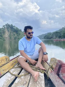 Prasenjit on a wooden boat on a calm lake